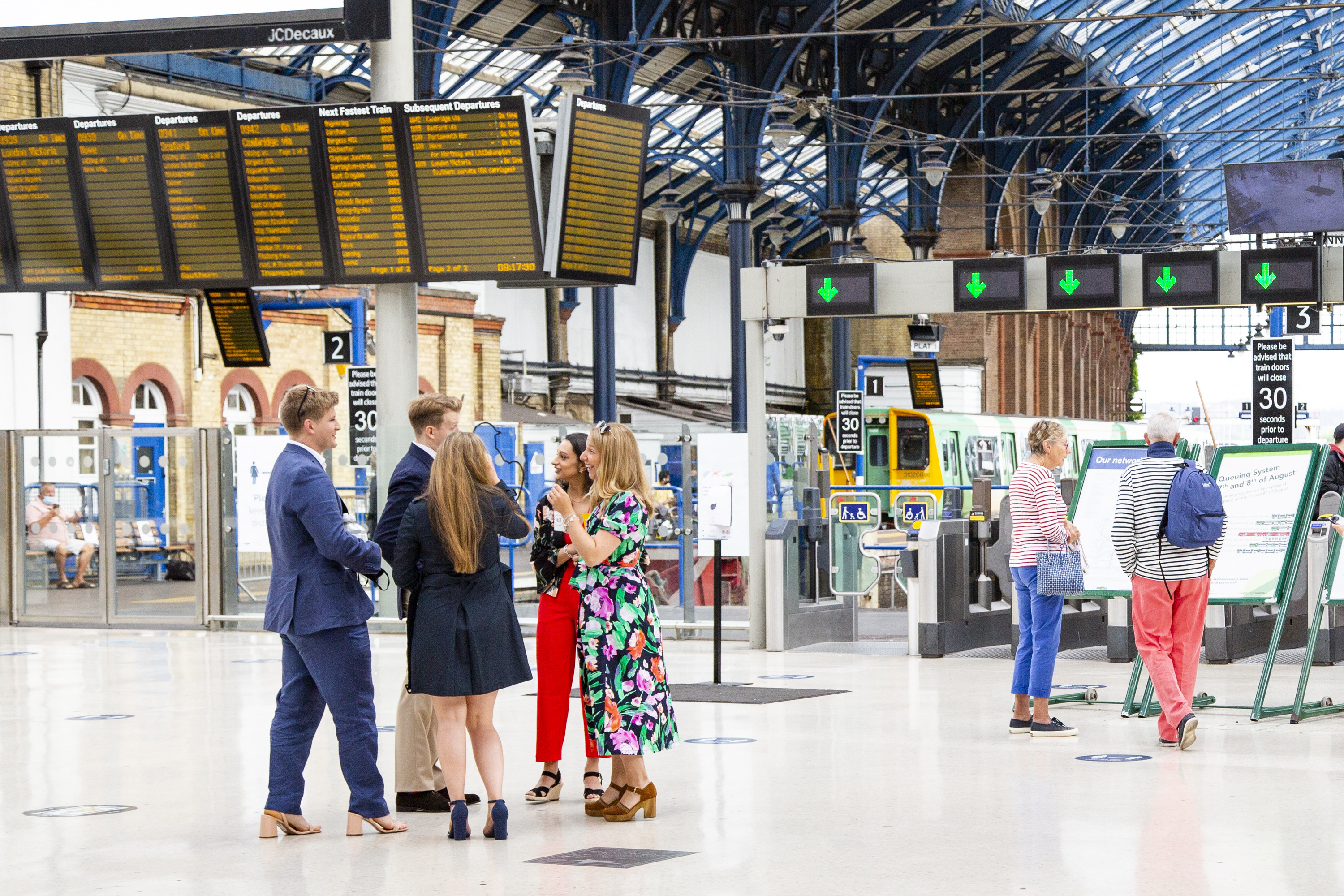 Brighton train station, group of young people waiting for train
